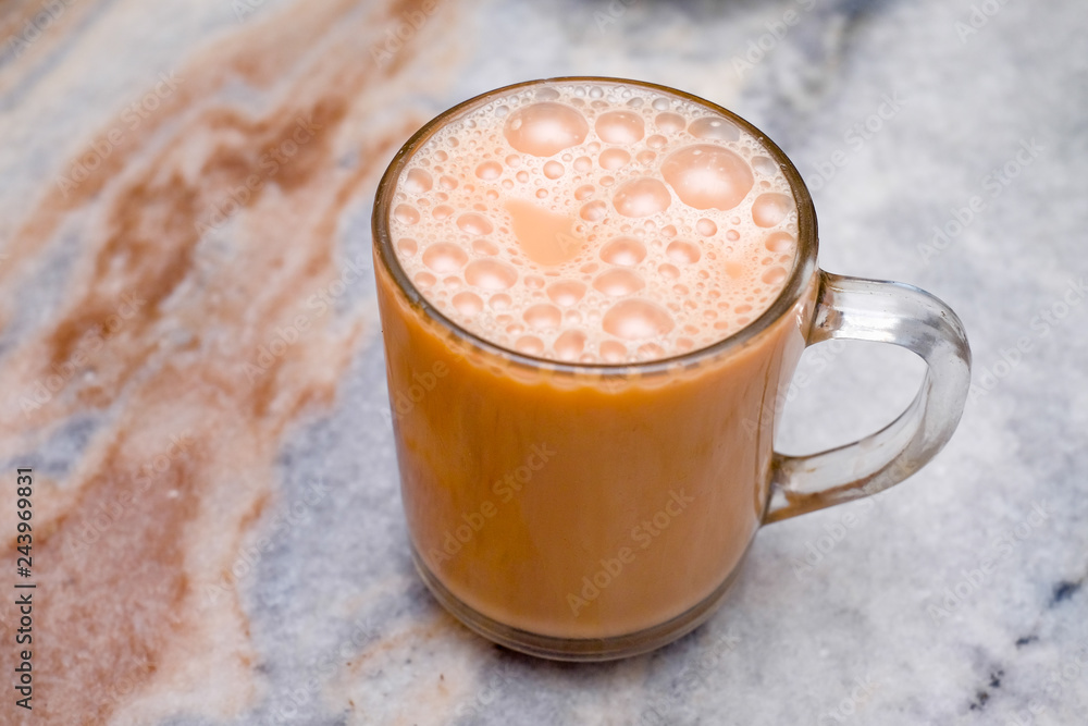 Teh tarik or pulled tea is a famous sweet milk tea in Malaysia. Bubble is floating on the surface of teh tarik. Teh tarik or pulled tea is a famous sweet milk tea in Malaysia. Bubble is floating on the surface of teh tarik.