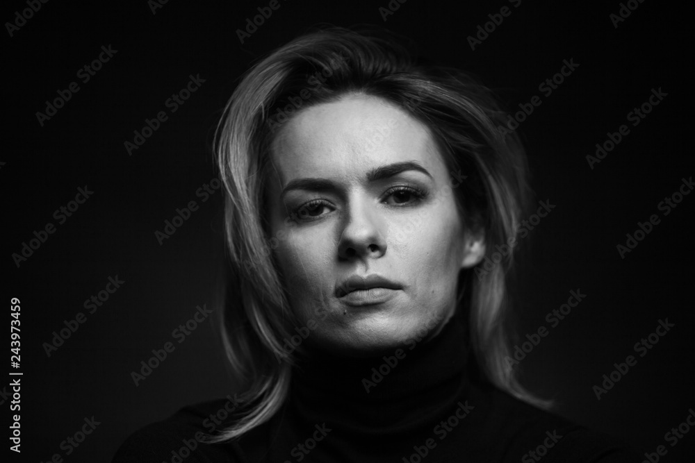 Dramatic black and white portrait of a beautiful woman on a dark background Dramatic black and white portrait of a beautiful woman on a dark background