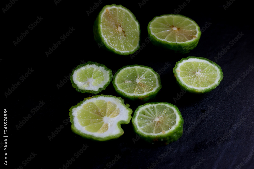 Bergamot or Kaffir lime Cut half isolate on black background
