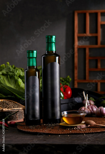 Fototapeta Naklejka Na Ścianę i Meble -  Black oil bottle in dark kitchen background