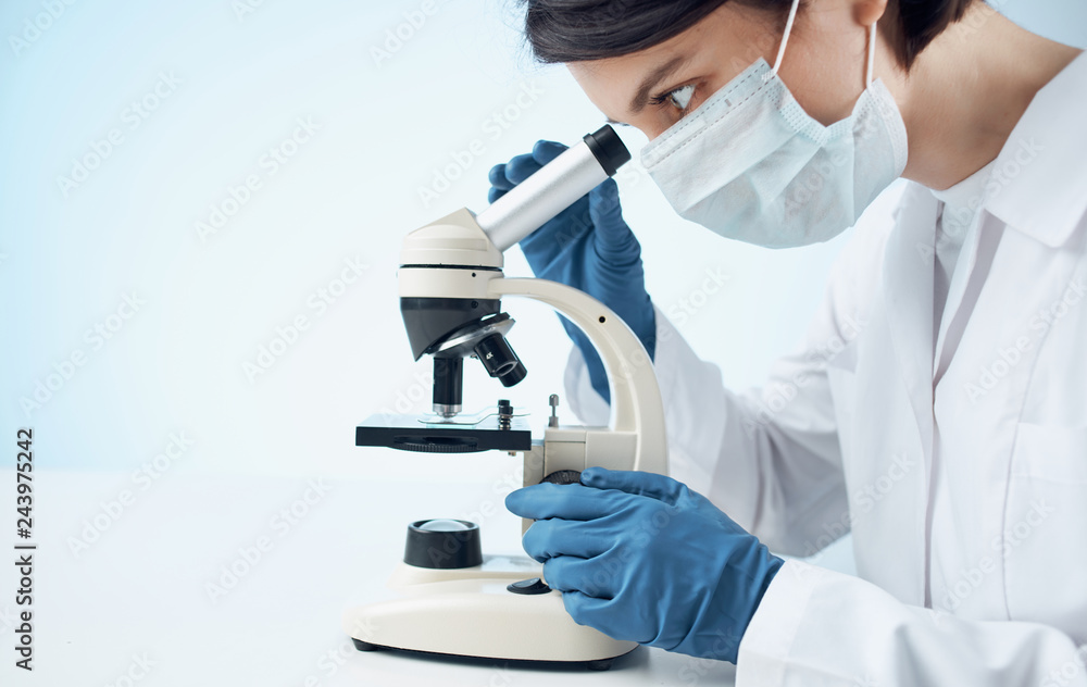 scientist looking through microscope in laboratory scientist looking through microscope in laboratory