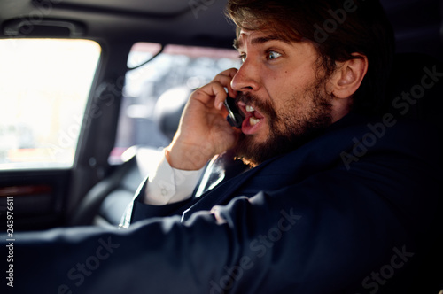 man talking on the phone sits behind the wheel of a car © SHOTPRIME STUDIO
