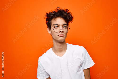 african man with glasses on orange background