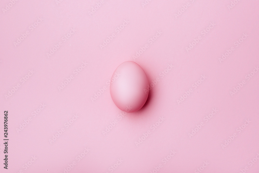 Pink egg on pink background - top view. copy space.