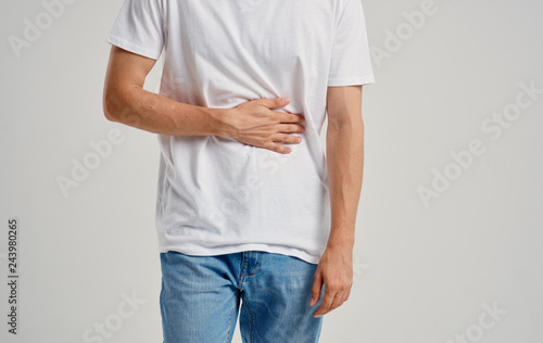 a man in a white T-shirt hurts his stomach