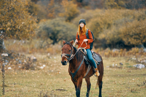 young woman riding a horse in nature