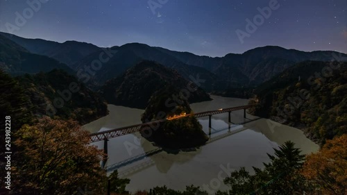 Astro Timelapse of Railroad Bridge over Lake in Moonlight in Japan  photo