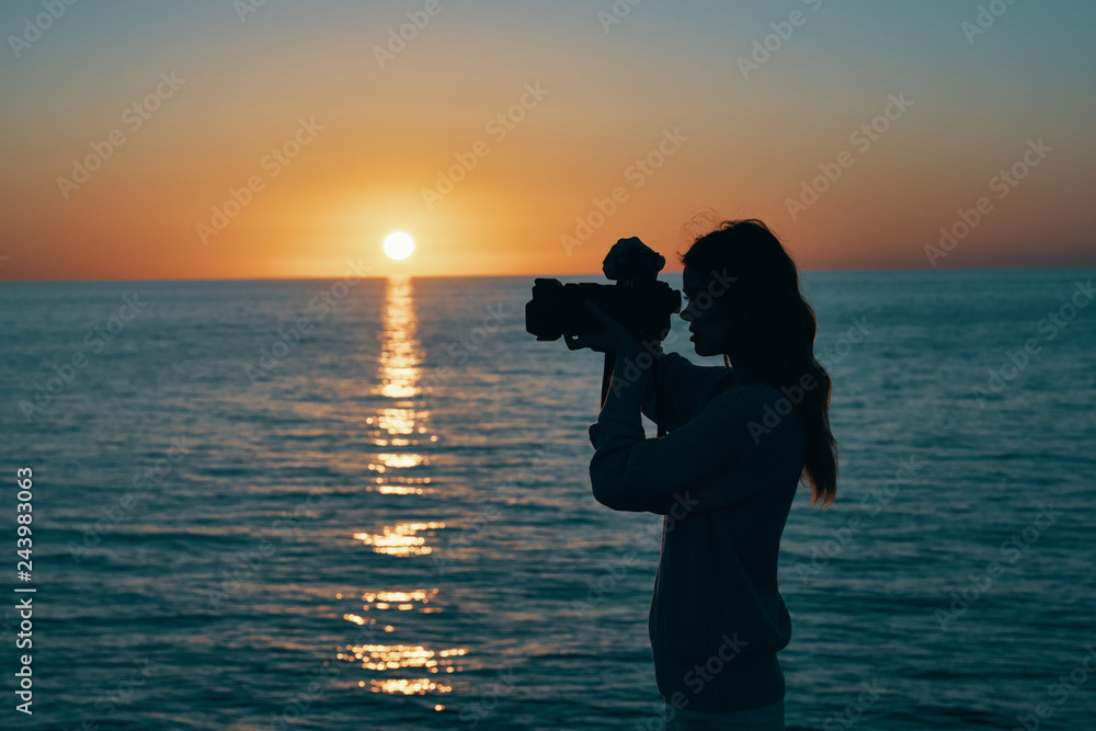 sunset at sea woman photographer with camera