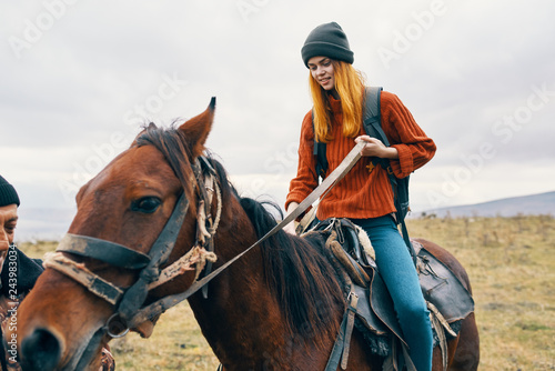 woman in a cap rides a horse in the fall in the mountains nature