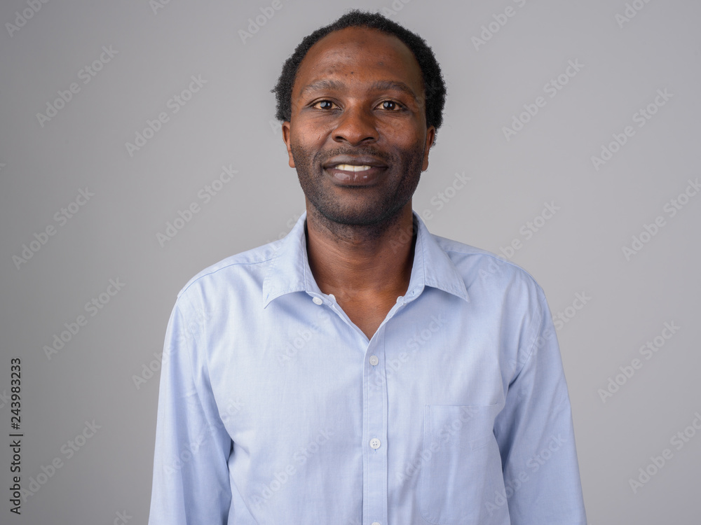 Happy African businessman smiling against white background
