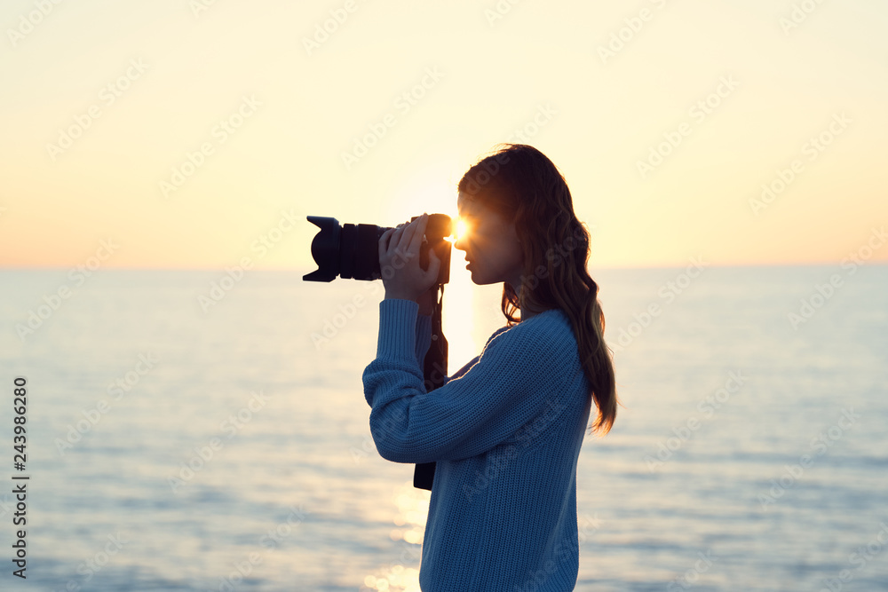 woman taking pictures of nature sea sunset