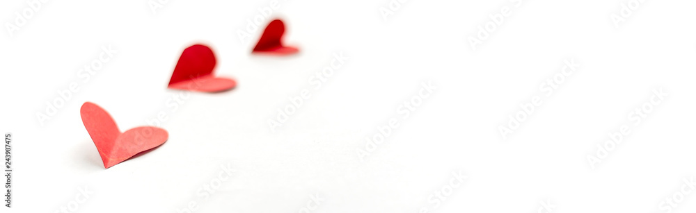 three red paper hearts isolated on white background, close up focused on nearest heart long banner three red paper hearts isolated on white background, close up focused on nearest heart long banner