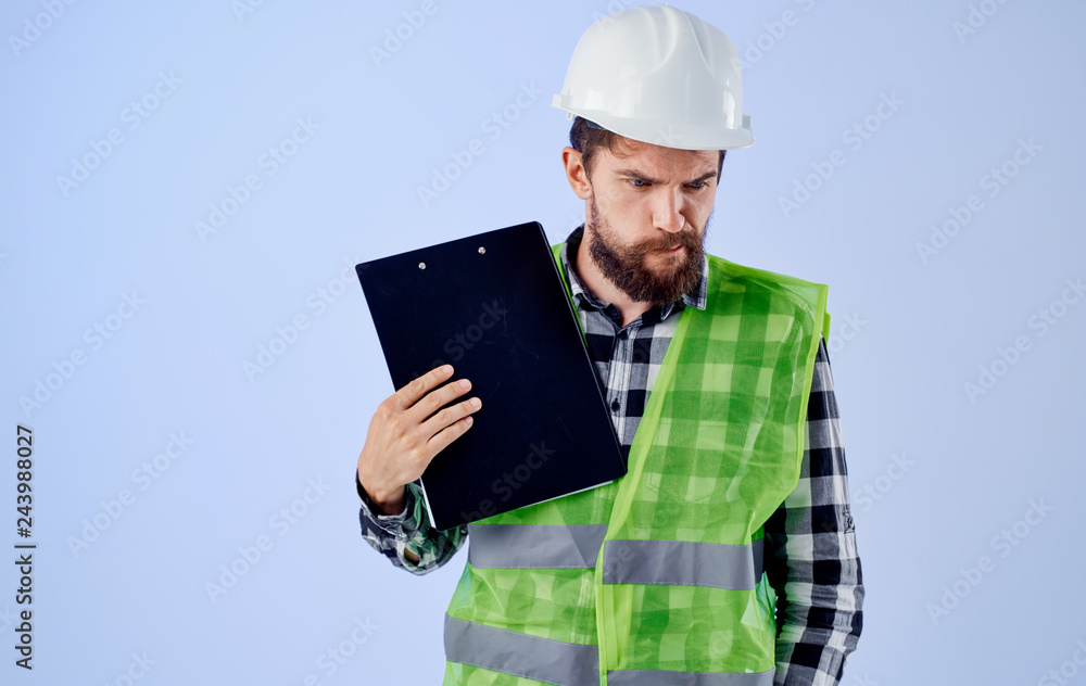 a builder in a helmet with documents thinks a builder in a helmet with documents thinks
