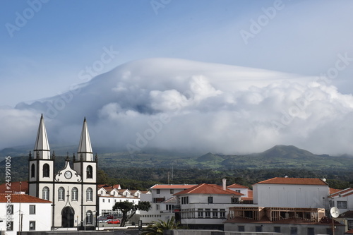 View of Madalena town with Pico mountain covered with clouds in the background