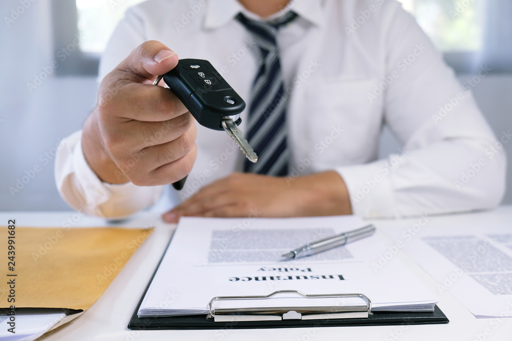 Car salesman handing over the keys for a new car. Car salesman handing over the keys for a new car.