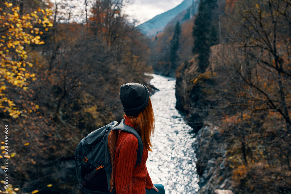 river hiking in the mountains nature traveler woman with a backpack