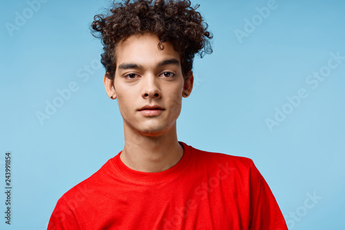 african man with curls on a blue background portrait
