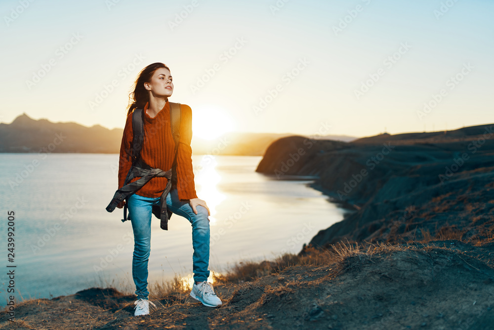 traveler woman with backpack sea coast sunset nature
