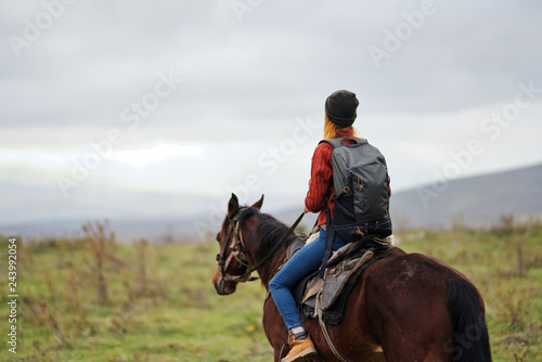 woman riding a horse in the mountains trip