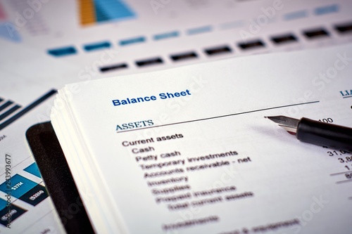 balance sheet and pen on the background of financial documents, close-up