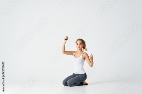 young woman in the gym with sports dumbbells