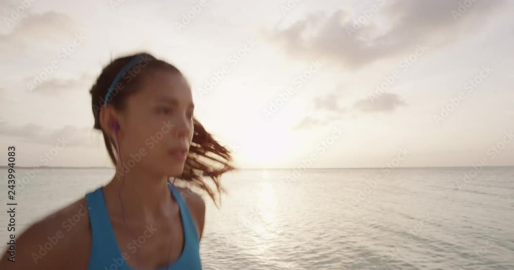 Female runner running on beach - summer vacations exercise. Asian female athlete on holiday travel working out her cardio listening to music in earphones. REAL TIME, RED EPIC. Female runner running on beach - summer vacations exercise. Asian female athlete on holiday travel working out her cardio listening to music in earphones. REAL TIME, RED EPIC.