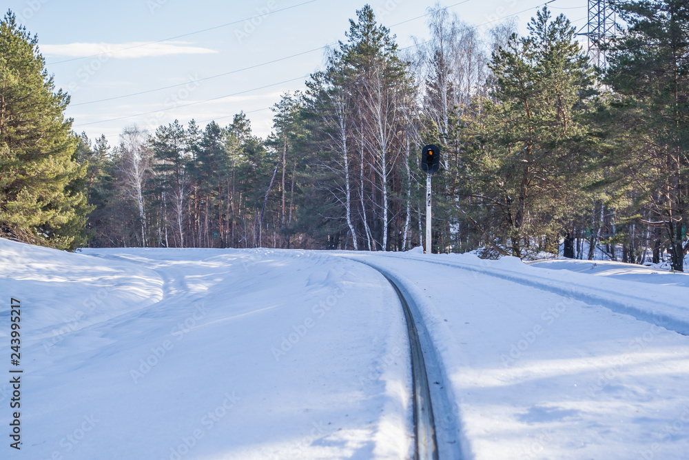 Railway semaphore in winter green pine forest. Blue sky and clouds. Morning in the winter forest. WInter forest landscape with railway. Railway semaphore in winter green pine forest. Blue sky and clouds. Morning in the winter forest. WInter forest landscape with railway.