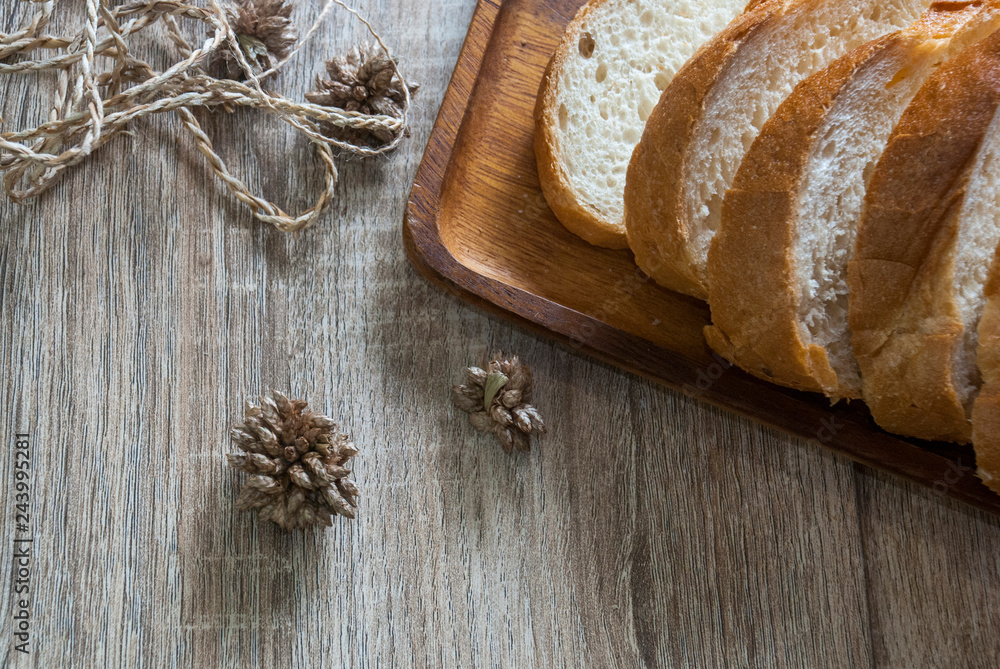 A piece of baguette cut into pieces on a wooden tray