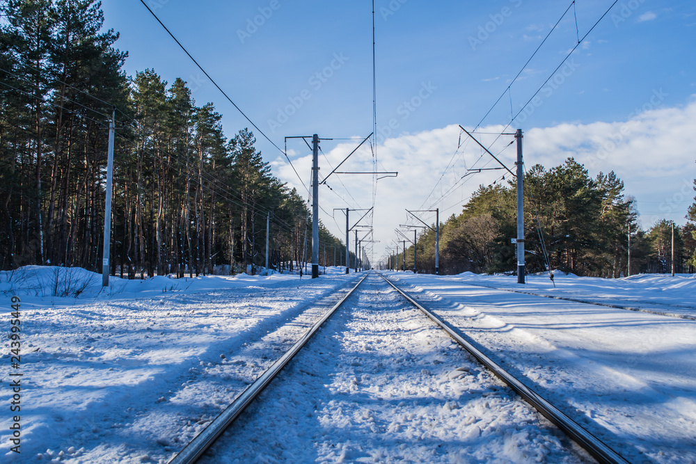 Snowy landscape with railway. Winter forest and blue sky. Beautiful morning in the forest.