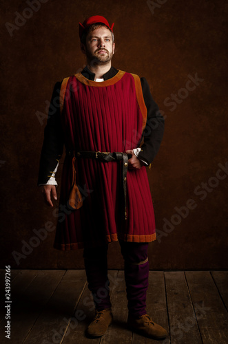 Foto man (actor) in a 15th century costume (medieval) on an aged stylized background