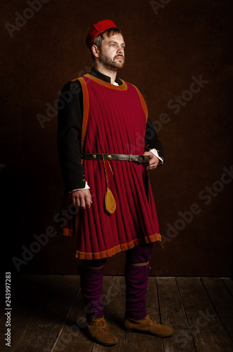 Fotografie man (actor) in a 15th century costume (medieval) on an aged stylized background