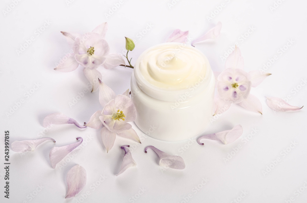 Cute flowers and petals and a jar of natural body cream isolated on white background