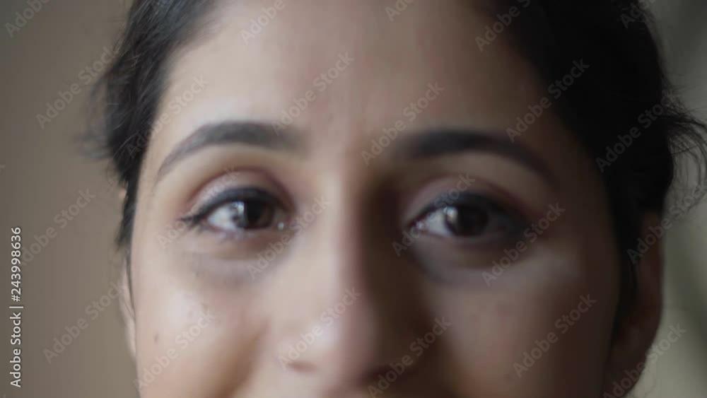 Closeup of young Latin female model. Eyes of beautiful black haired girl with makeup looking at camera and smiling. Closeup portrait concept Closeup of young Latin female model. Eyes of beautiful black haired girl with makeup looking at camera and smiling. Closeup portrait concept