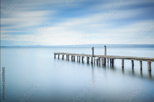 Wooden pier or jetty remains on a blue lake. Long Exposure. © stevanzz
