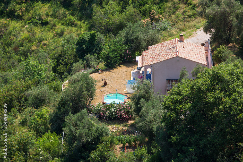 A small French house and swinmming pool as seen from above near the hilltop village of Sainte Agnes, south of France