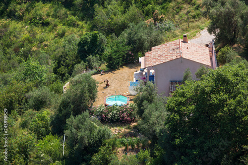 A small French house and swinmming pool as seen from above near the hilltop village of Sainte Agnes, south of France photo