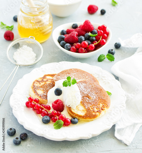 Breakfast - Cottage cheese pancakes   curd fritters with raspberry  strawberry  blueberry.  Selective focu