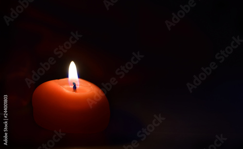 Red burning candle against dark or black background to celebration 