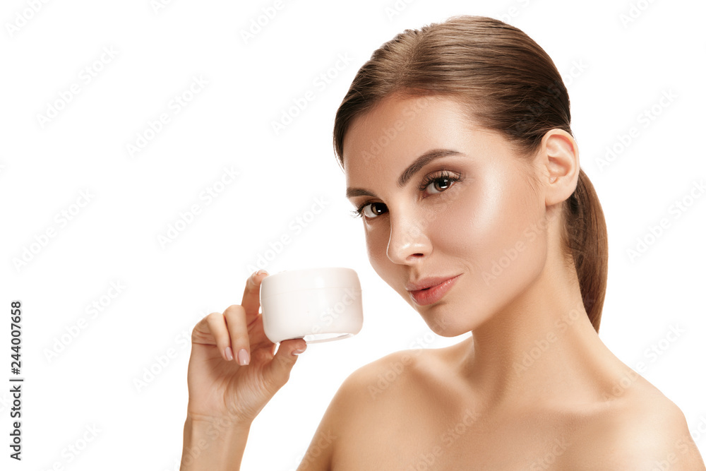 Cute girl preparing to start her day. She is applying moisturizer cream on face at studio. The beauty, care, skin, treatment, health, spa, cosmetic and advertising concept Cute girl preparing to start her day. She is applying moisturizer cream on face at studio. The beauty, care, skin, treatment, health, spa, cosmetic and advertising concept