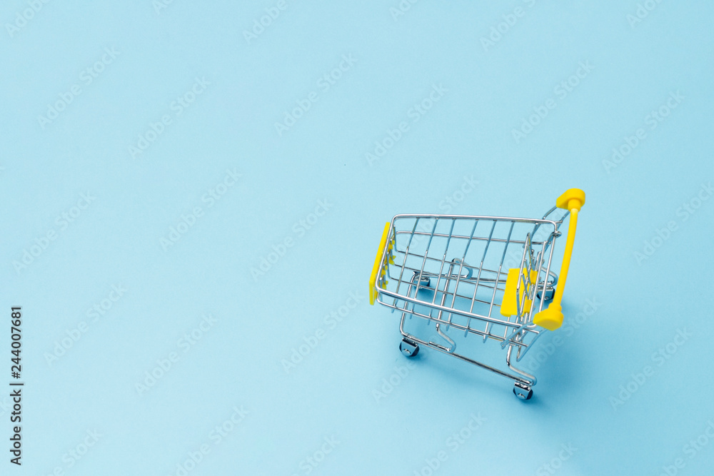 Shopping cart from the supermarket on an isolated blue background. Shopping in the Mall, shop, shopping, a large selection. Question mark. Flat lay, top view.