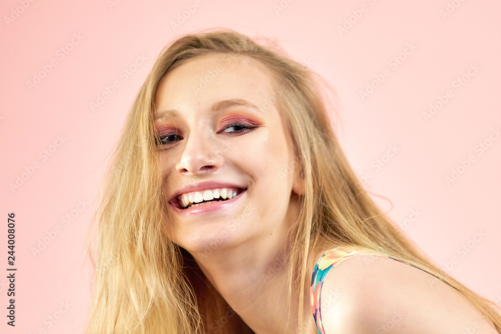 Fototapeta premium Happy cheerful young woman wearing her red hair in bun rejoicing at positive news or birthday gift, looking at camera with joyful and charming smile. Ginger student girl relaxing indoors after college