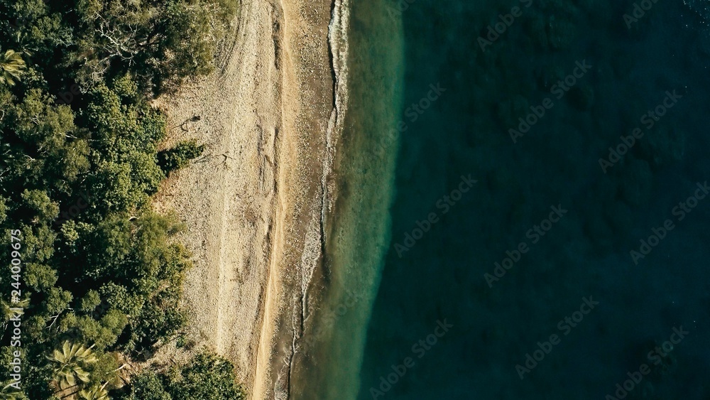 stunning aerial drone minimal geometric image of a remote tropical sea ocean shore with sandy beach lush rainforest jungle and crystal clear azure blue water from top looking down at sunset stunning aerial drone minimal geometric image of a remote tropical sea ocean shore with sandy beach lush rainforest jungle and crystal clear azure blue water from top looking down at sunset