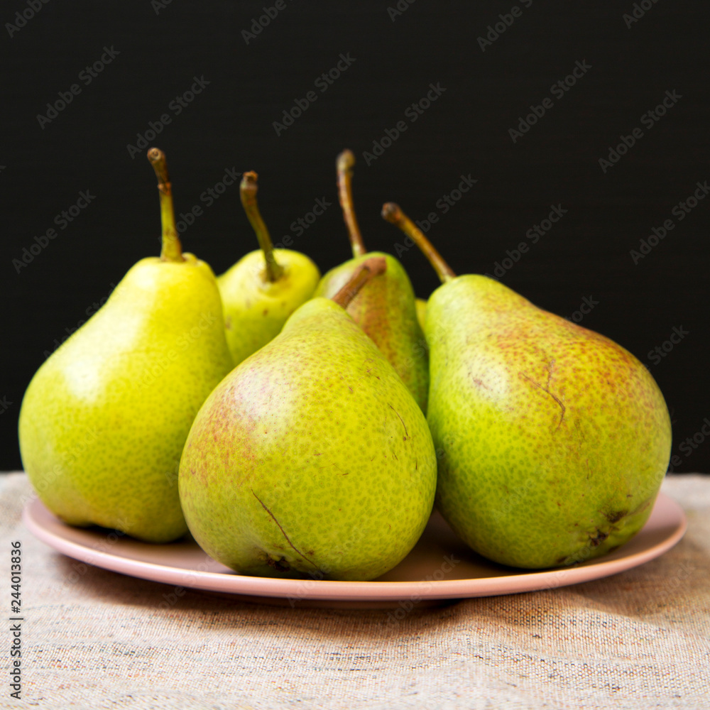 Tasty fresh pears on pink plate, side view. Closeup. Tasty fresh pears on pink plate, side view. Closeup.
