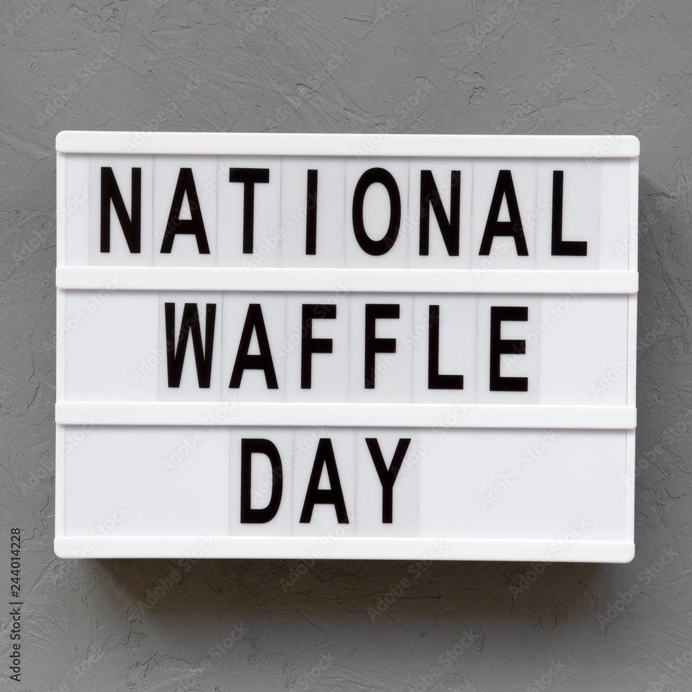 'National Waffle Day' word on modern board over concrete background, top view. From above, overhead.