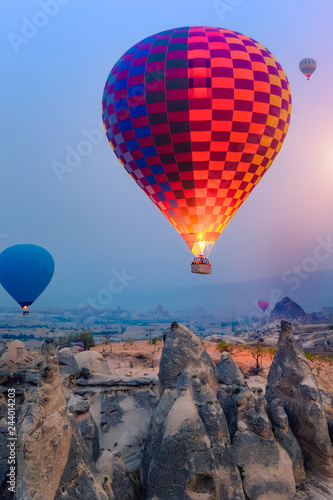 Beautiful hot air balloons flying over Cappadocia landscape at sunrise