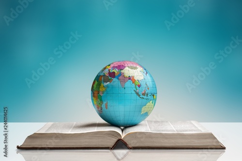 Heavy book and globe on background