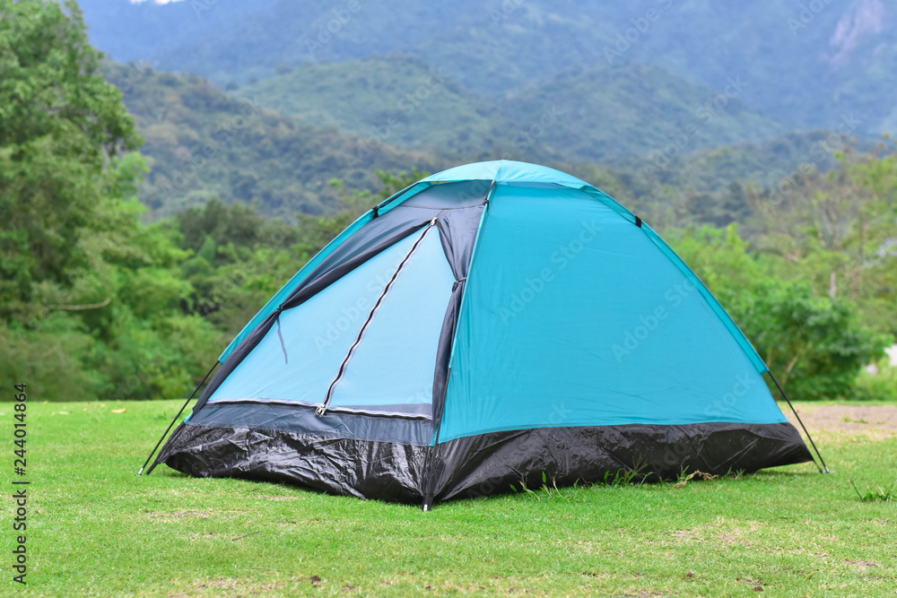 Light blue color backpack tent and mountain range landscapes in the background.