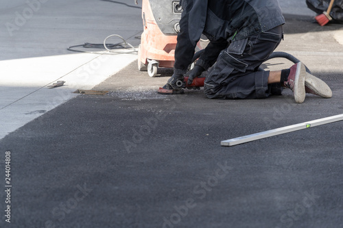 Man using grinder and correct high of asphalt on street