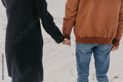 couple holding by hands, winter time.