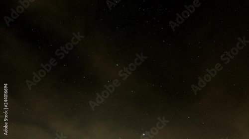 Timelapse of a night sky. yellowish red clouds fly along the firement as the stars wander. Taken in a blood moon night photo